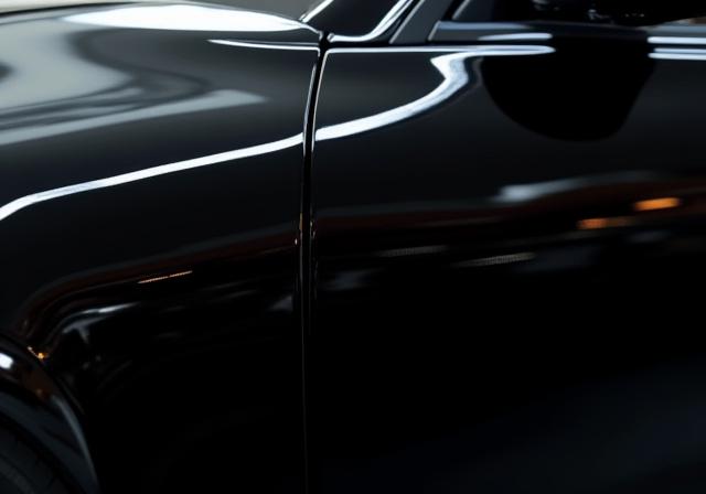 The same black sedan with a deep, mirror-like finish after paint correction and ceramic coating.